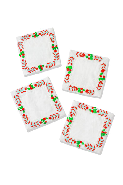 Set of four napkins with red and green border designs on a white background.