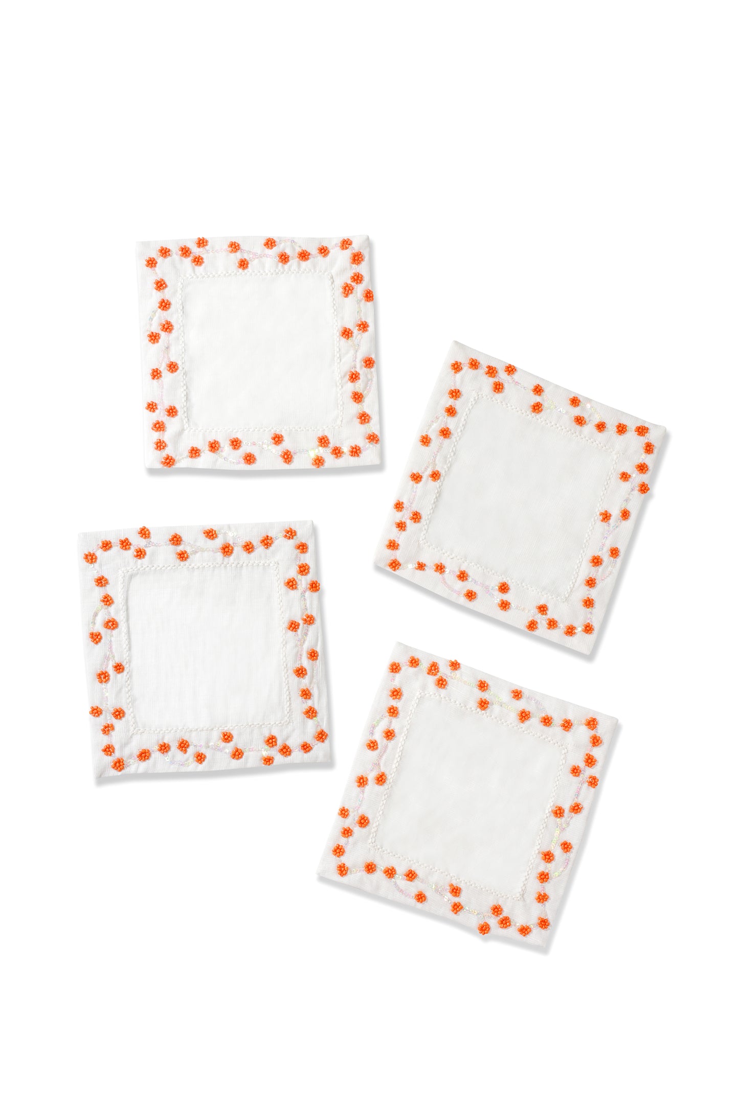 Four white square patches with orange polka dots on a white background