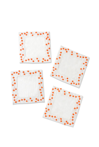 Four white square patches with orange polka dots on a white background