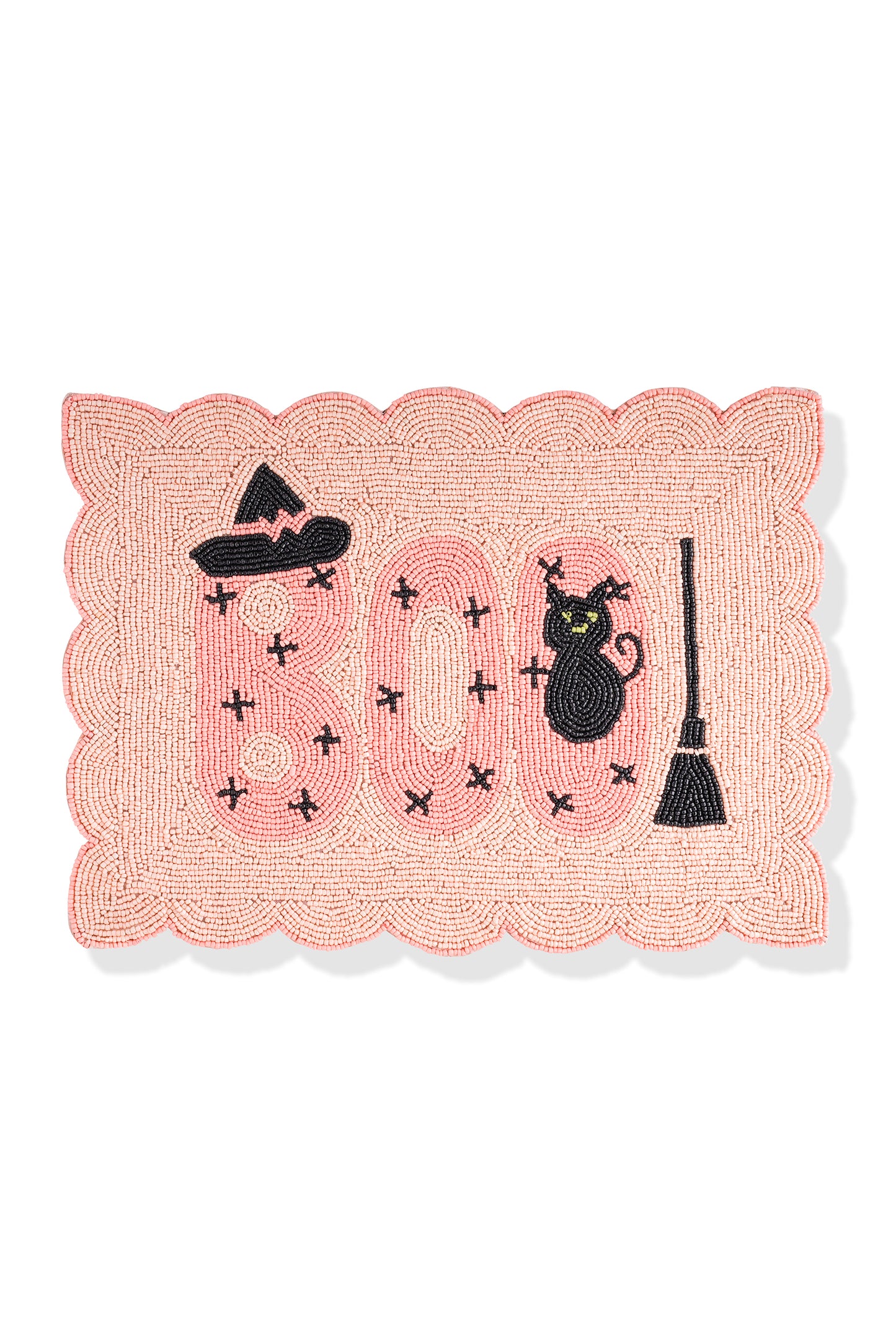 A rectangular woven Halloween mat with a scalloped pink border, featuring the word 'BOO' in pink with black stitched crosses, a black witch hat, a black cat, and a black broomstick on a white background.